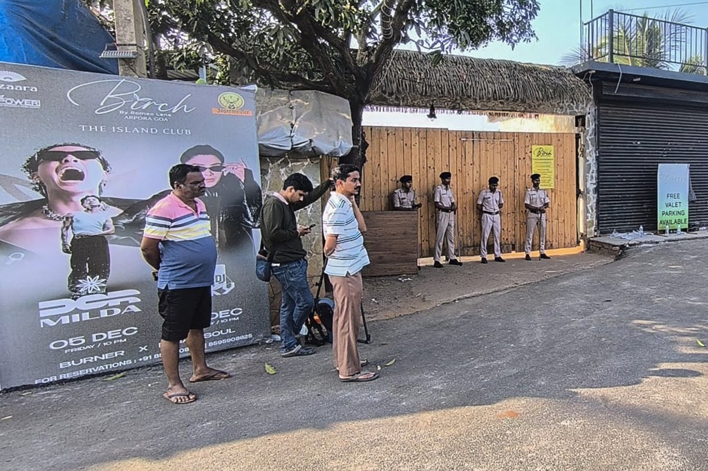 Police personnel stand guard outside the nightclub following the fire, where at least 25 people including tourists were killed.