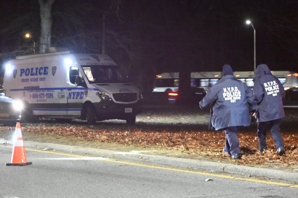 NYPD officers and a crime scene unit van at the site of human remains found on the Major Deegan Expressway.
