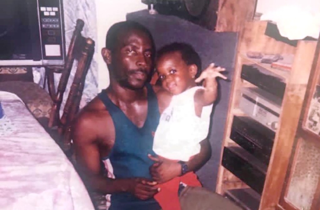 Trevor Lloyd Samuels holding his granddaughter Janelle.