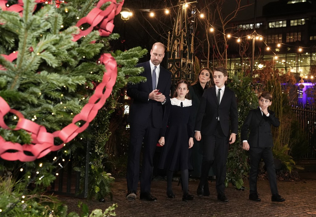 Prince William, Princess Catherine, and their children Prince George, Princess Charlotte, and Prince Louis looking at messages on the Kindness Tree.