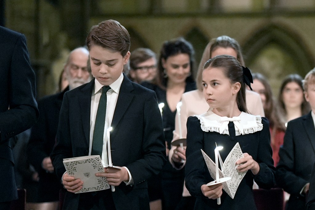Prince George and Princess Charlotte holding carol service programs and candles.