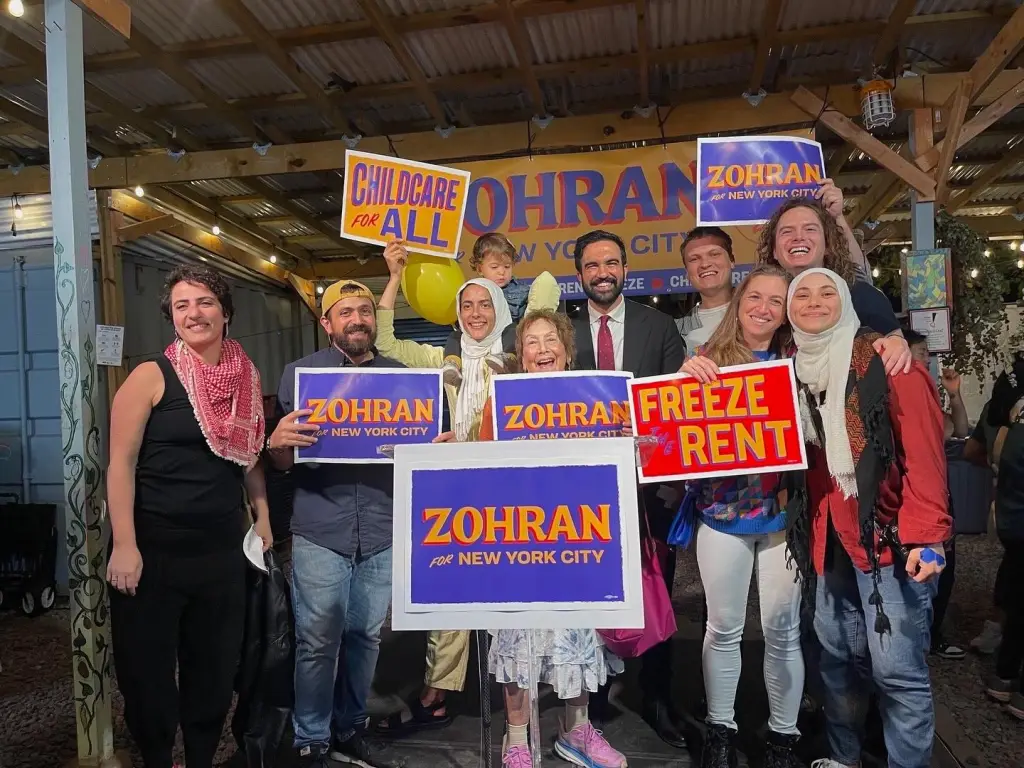 Aber Kawas, far right, with Zohran Mamdani, center, and supporters holding 
