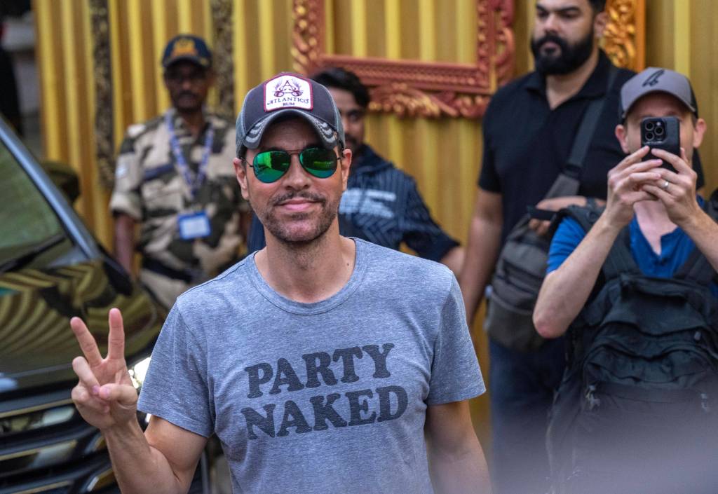 Enrique Iglesias poses for photographers as he arrives at Kalina airport.