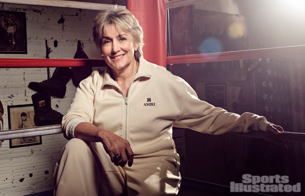 A woman sitting in a boxing ring.