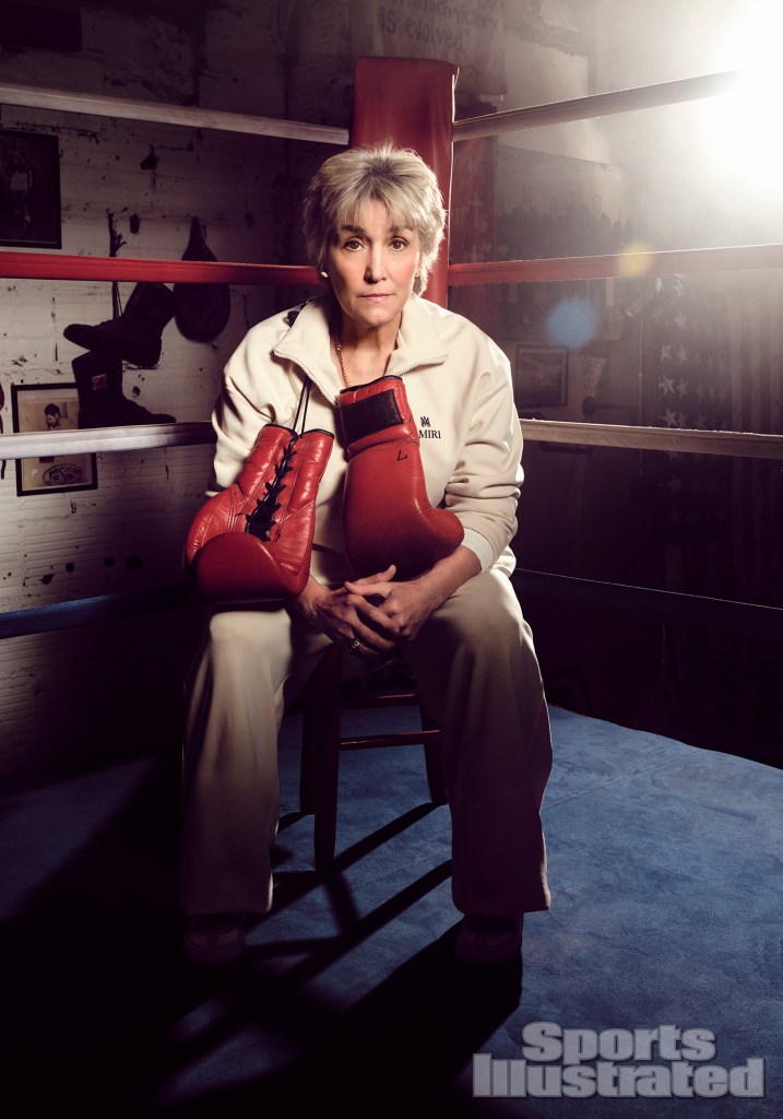 A woman sitting in a boxing ring.