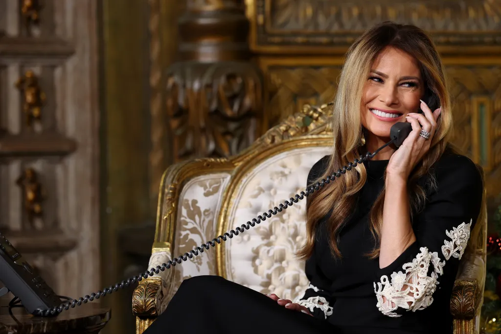 Melania Trump smiling while on the phone participating in the NORAD Santa Tracker event.