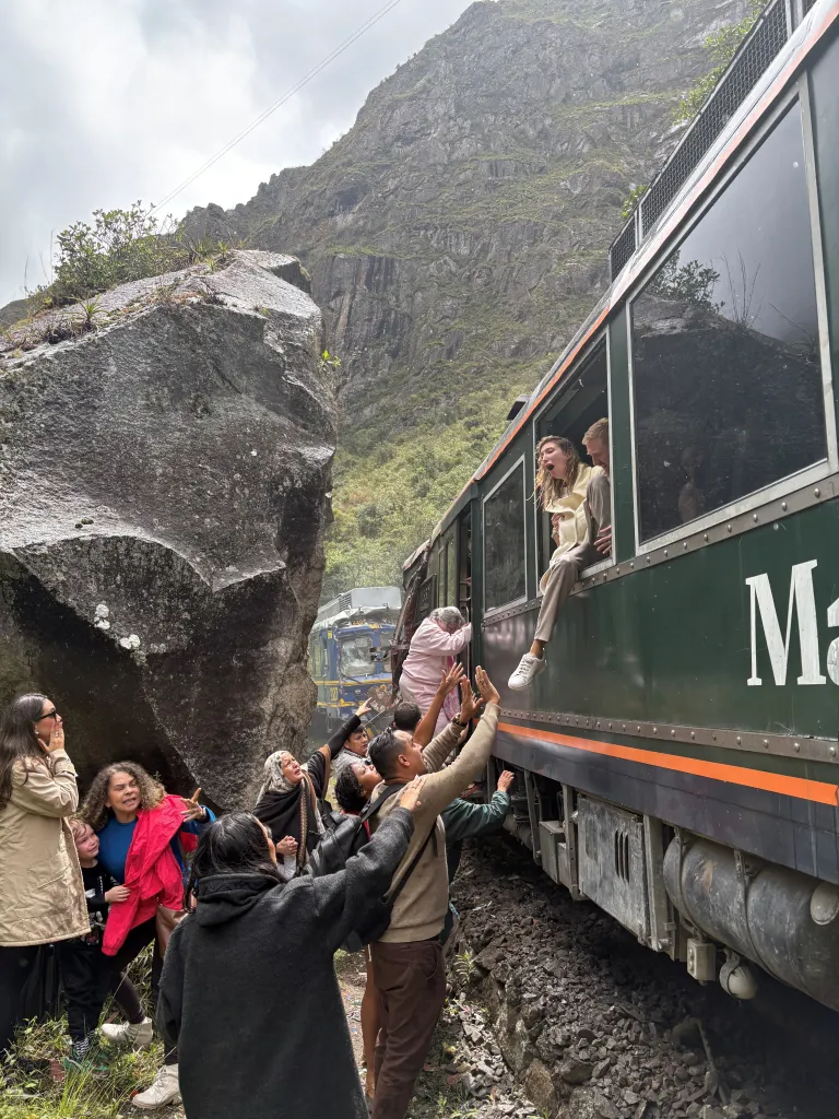 People evacuating a train carriage after two trains collided head-on near Machu Picchu.