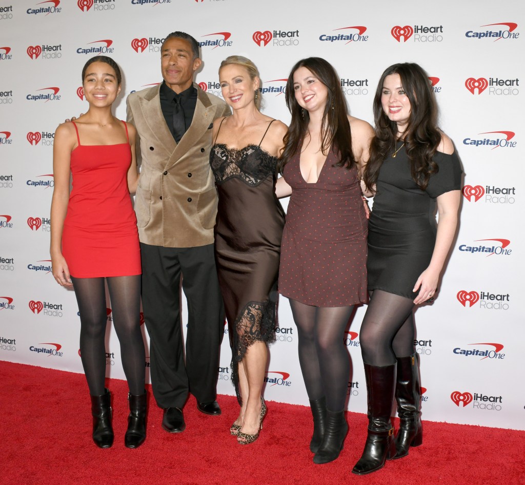 T.J. Holmes, Amy Robach, and their three daughters, Sabine Holmes, Ava McIntosh, and Annie McIntosh, pose together on a red carpet.