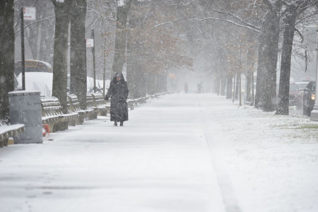 A woman walks in the snow.
