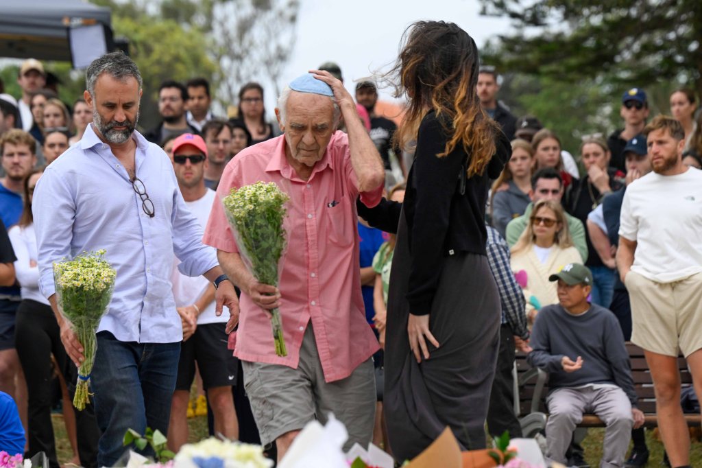 People lay flowers at Bondi Pavilion in tribute to victims of a terrorist attack.