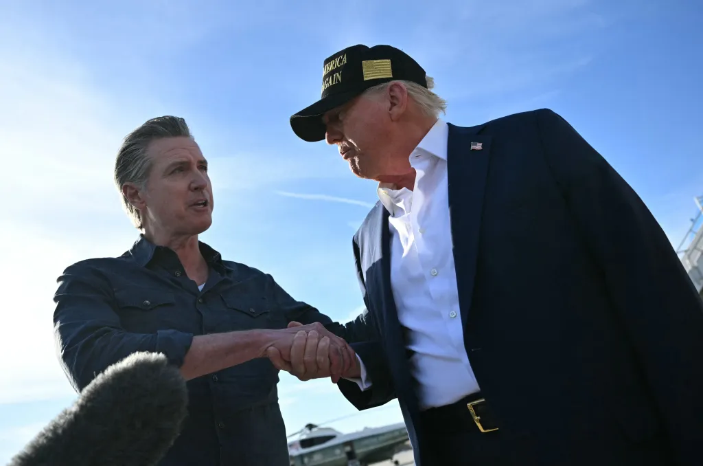 President Donald Trump shakes hands with California Governor Gavin Newsom as he speaks to the press upon arrival at Los Angeles International Airport in Los Angeles, California, on January 24, 2025, to visit the region devastated by the Palisades and Eaton fires.