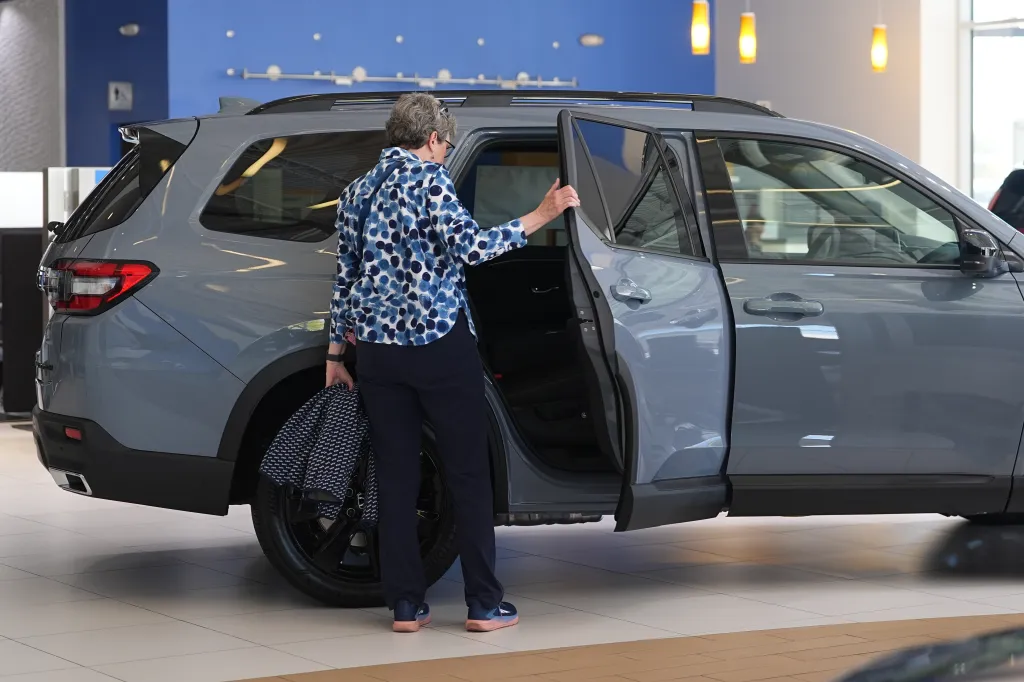 A car shopper browses a Honda dealership lot in Highlands Ranch, Colo. in October as average monthly payments climb to about $760 and loan terms stretch longer.