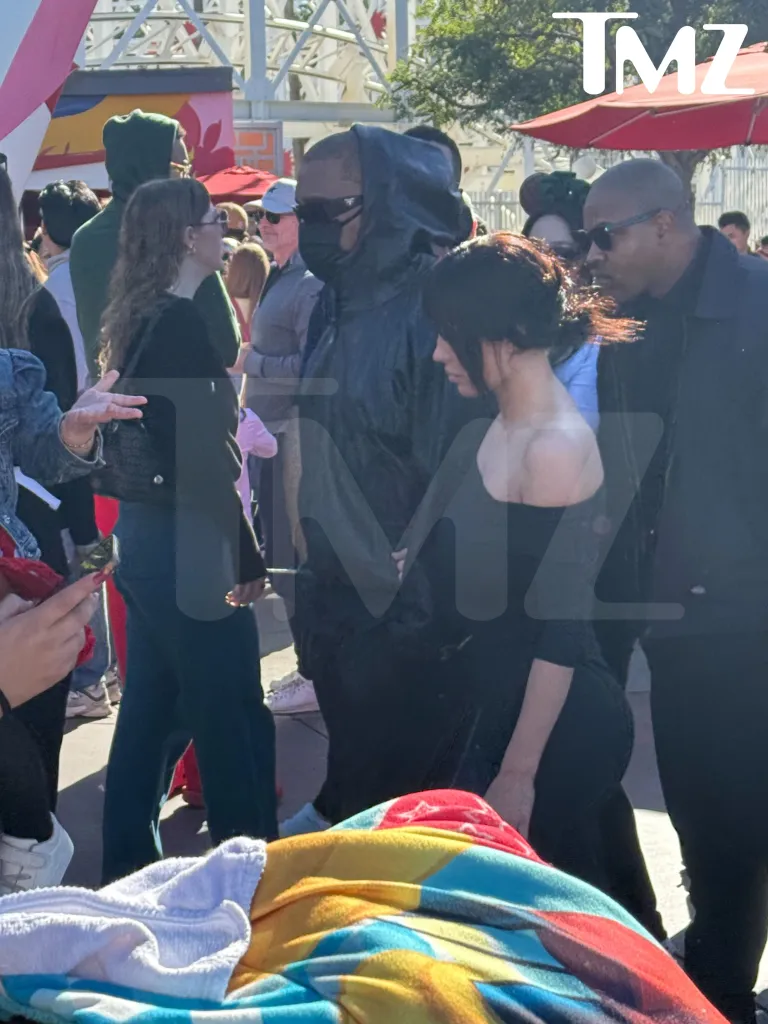 Bianca Censori in a black dress with Kanye West at Disneyland.