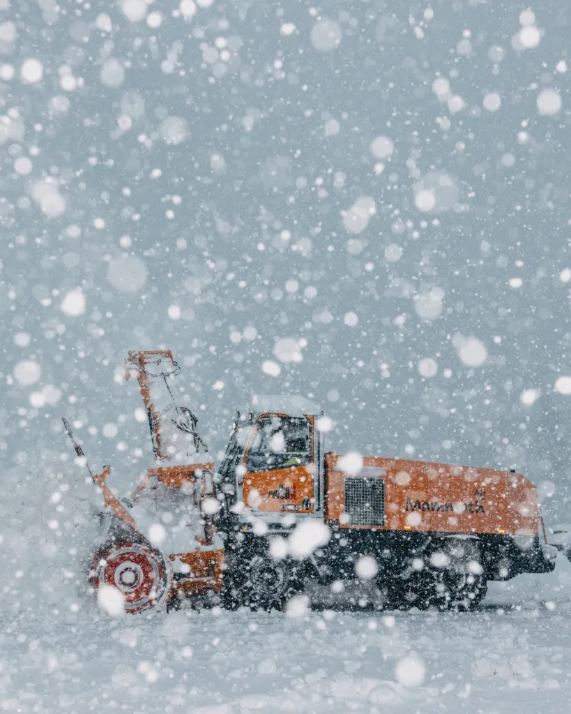 Orange snow groomer with 