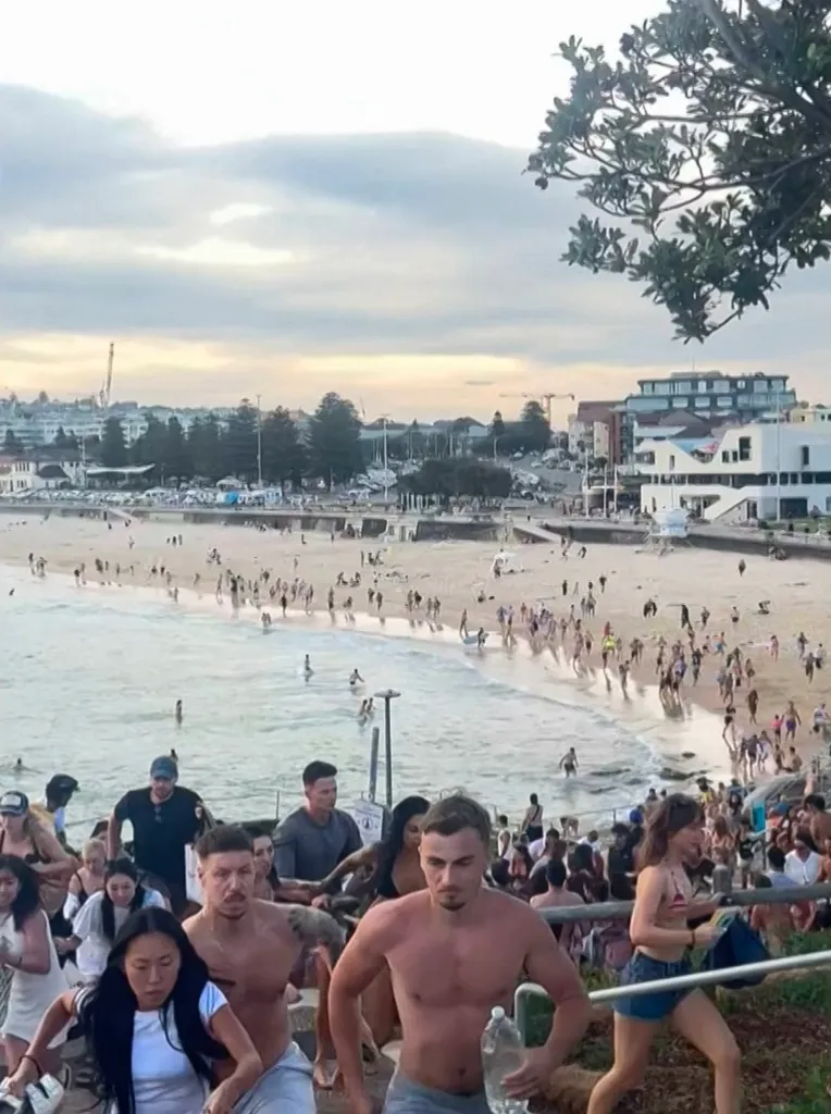 This screen grab of UGC video taken on December 14, 2025 and received courtesy of Mike Ortiz shows beach-goers fleeing Bondi Beach after gunmen opened fire, in Sydney on December 14, 2025.