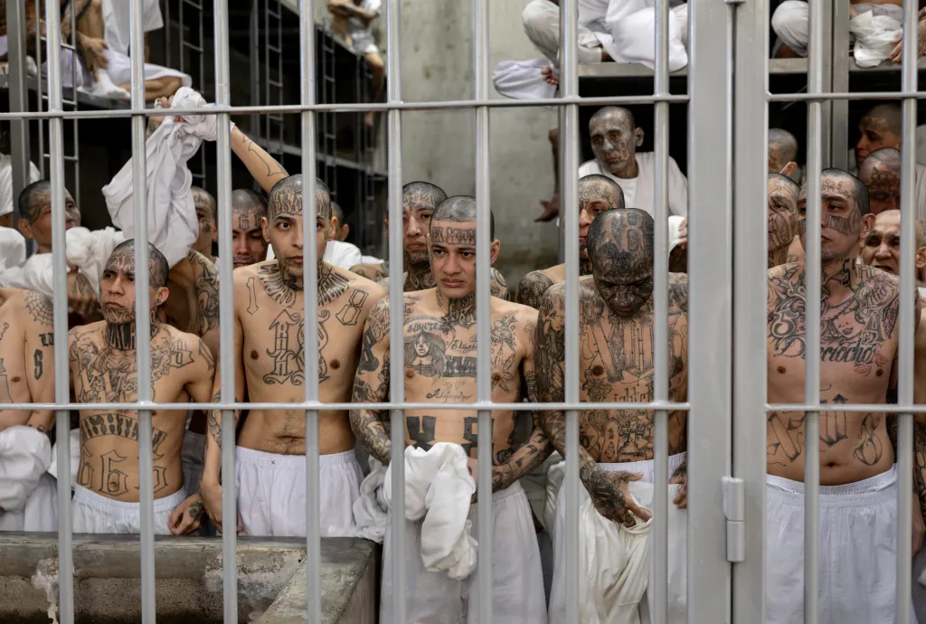 Inmates remove their shirts after guards instructed them to display gang-affiliated tattoos at CECOT (Counter Terrorism Confinement Center) on December 15, 2025 in Tecoluca, El Salvador.