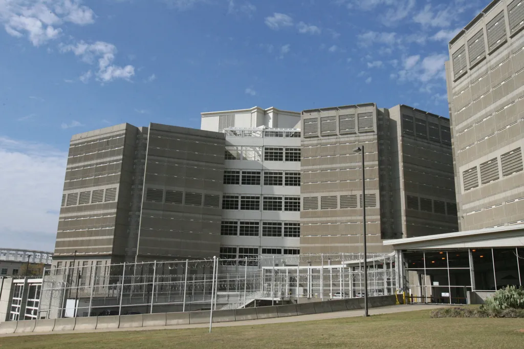Large, modern prison facility under a blue sky with scattered clouds.