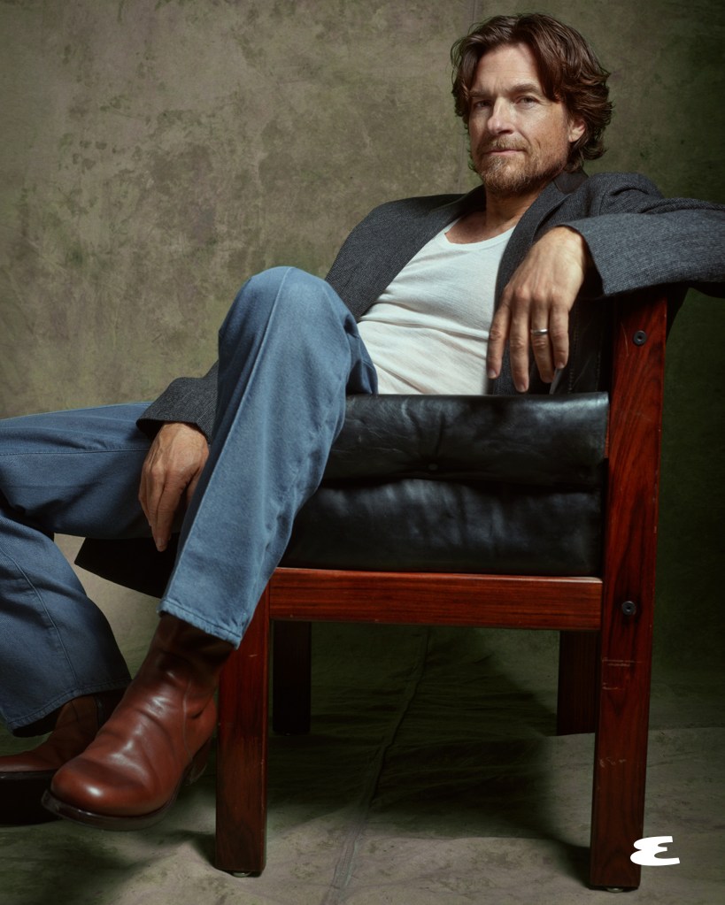 Jason Bateman sitting in a dark leather and wood chair.