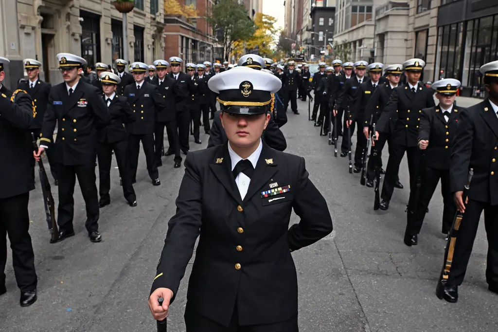 Veterans Day parade with sailors marching in uniform.