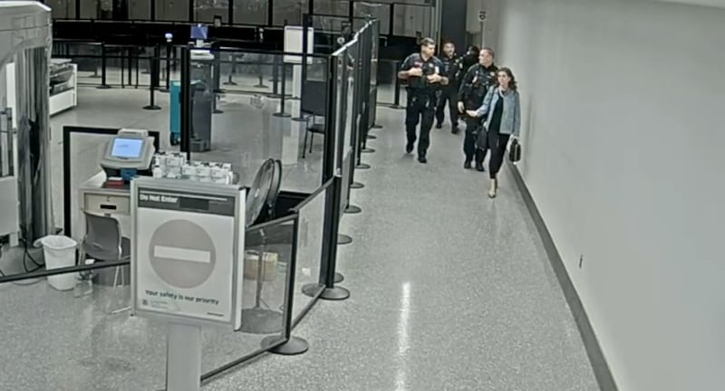 Mace clashing with agents and officers at the airport.