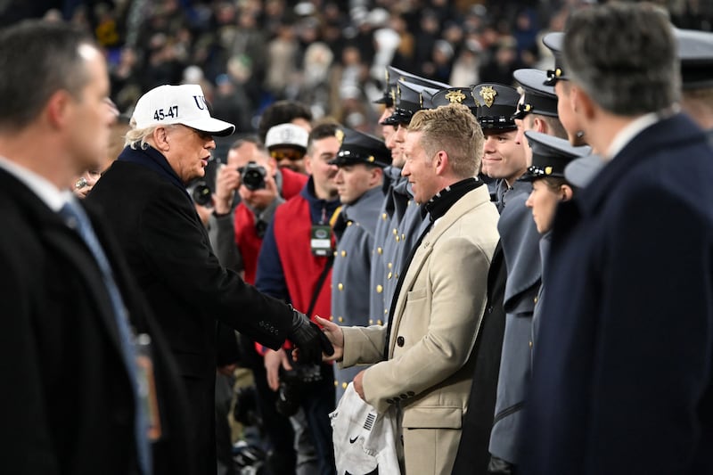 US President Donald Trump shakes hands with Army West Point New Director of Athletics Tom Theodorakis during the college football game between the Army and Navy at the M&T Bank Stadium in Baltimore, Maryland, on December 13, 2025. (Photo by Alex WROBLEWSKI / AFP via Getty Images)
