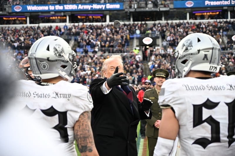 US President Donald Trump tosses a coin before the college football game between the US Army and Navy at the M&T Bank Stadium in Baltimore, Maryland, on December 13, 2025. (Photo by Alex WROBLEWSKI / AFP via Getty Images)