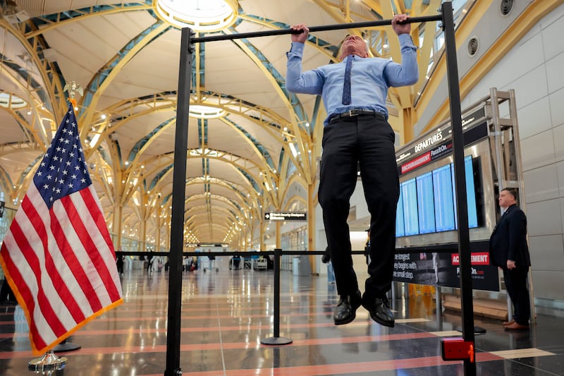 Human Services Secretary Robert F. Kennedy Jr. does pull-ups after a conference discussing the launch of the "Make Travel Family Friendly Again" campaign at Ronald Reagan Washington National Airport on December 8, 2025.