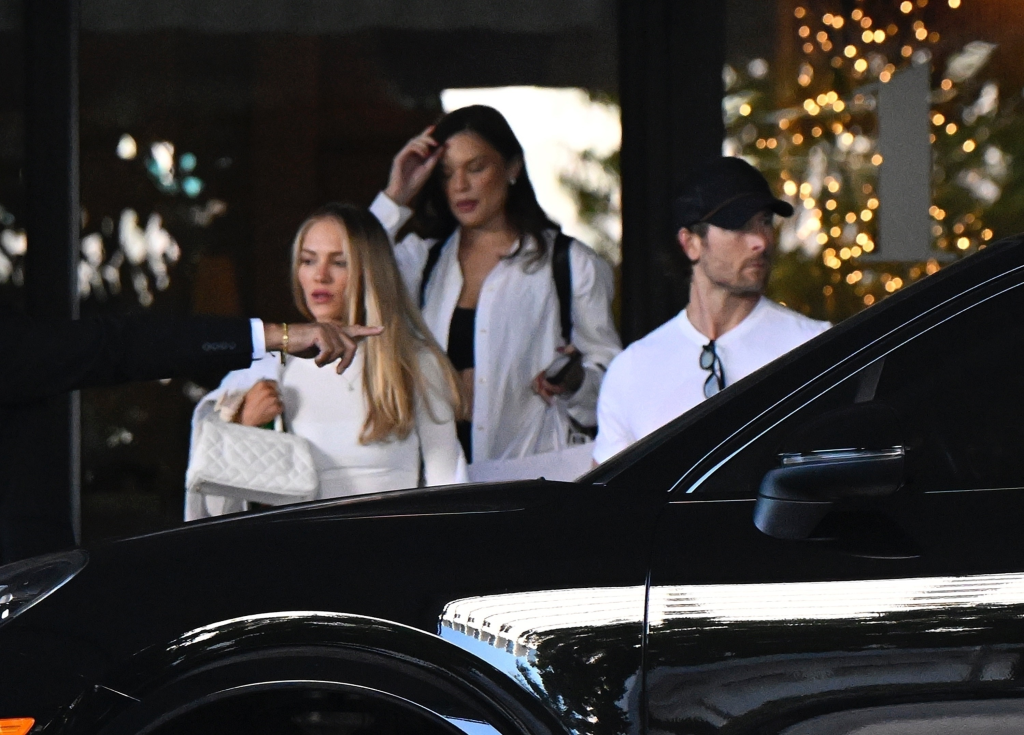 Glen Powell opening a car door for Michelle Randolph.