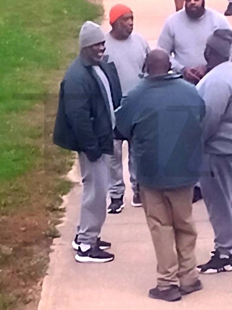 Diddy smiling and chatting with other inmates in the yard at Fort Dix.