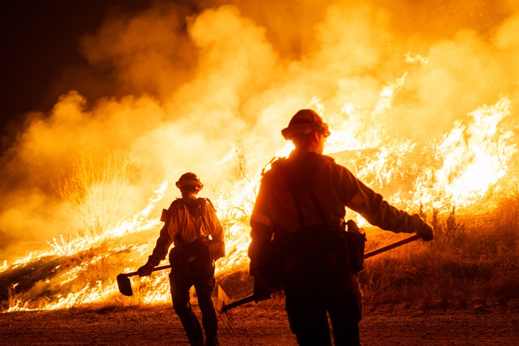 Firefighters work as the Hughes Fire burns on January 22, 2025 in Castaic, California.