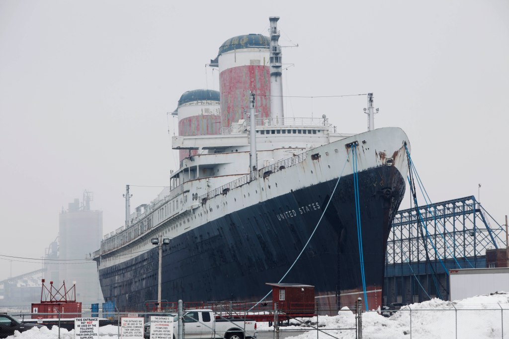 The historic cruise ship SS United States docked at a port on a snowy day.