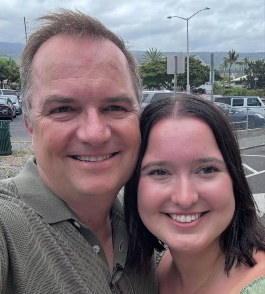 A man and a young woman smiling at the camera.