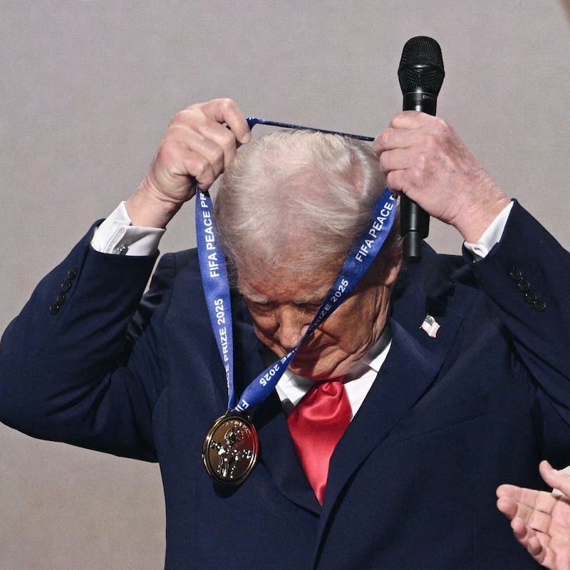 (L-R) US President Donald Trump puts on a medal as he receives the FIFA Peace Prize from FIFA President Gianni Infantino during the draw for the 2026 FIFA Football World Cup taking place in the US, Canada and Mexico, at the Kennedy Center, in Washington, DC, on December 5, 2025. (Photo by Brendan SMIALOWSKI / AFP via Getty Images)