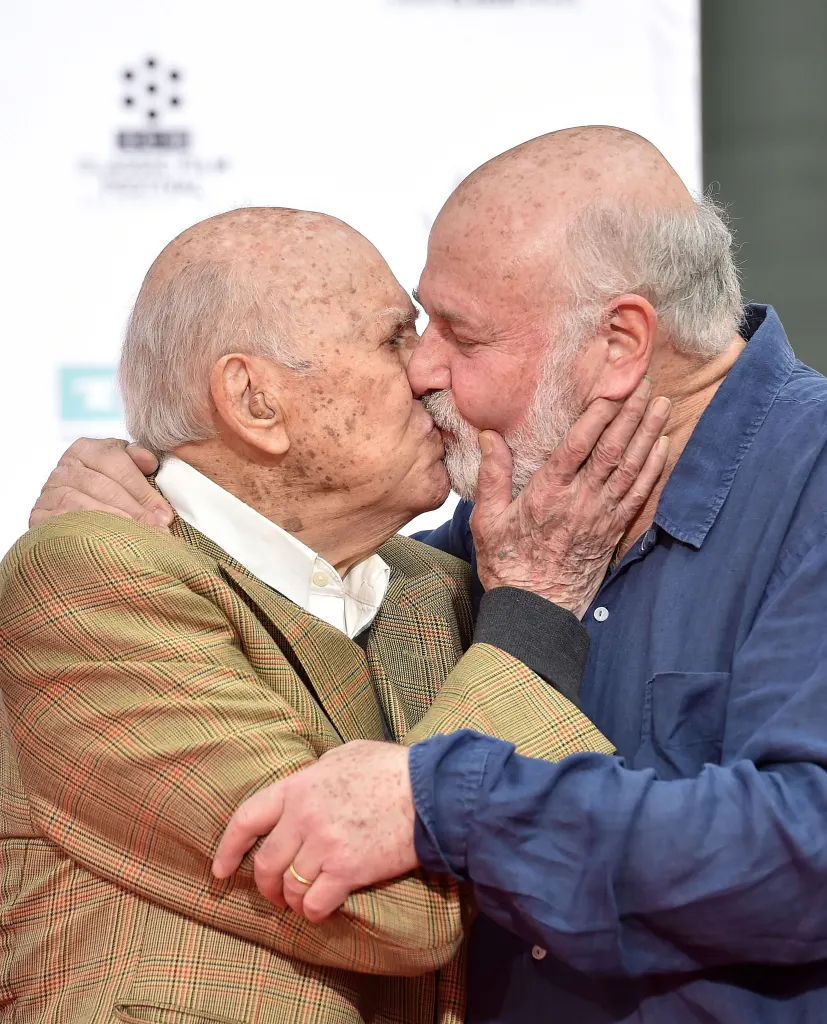 Carl Reiner and Rob Reiner kissing on the lips.