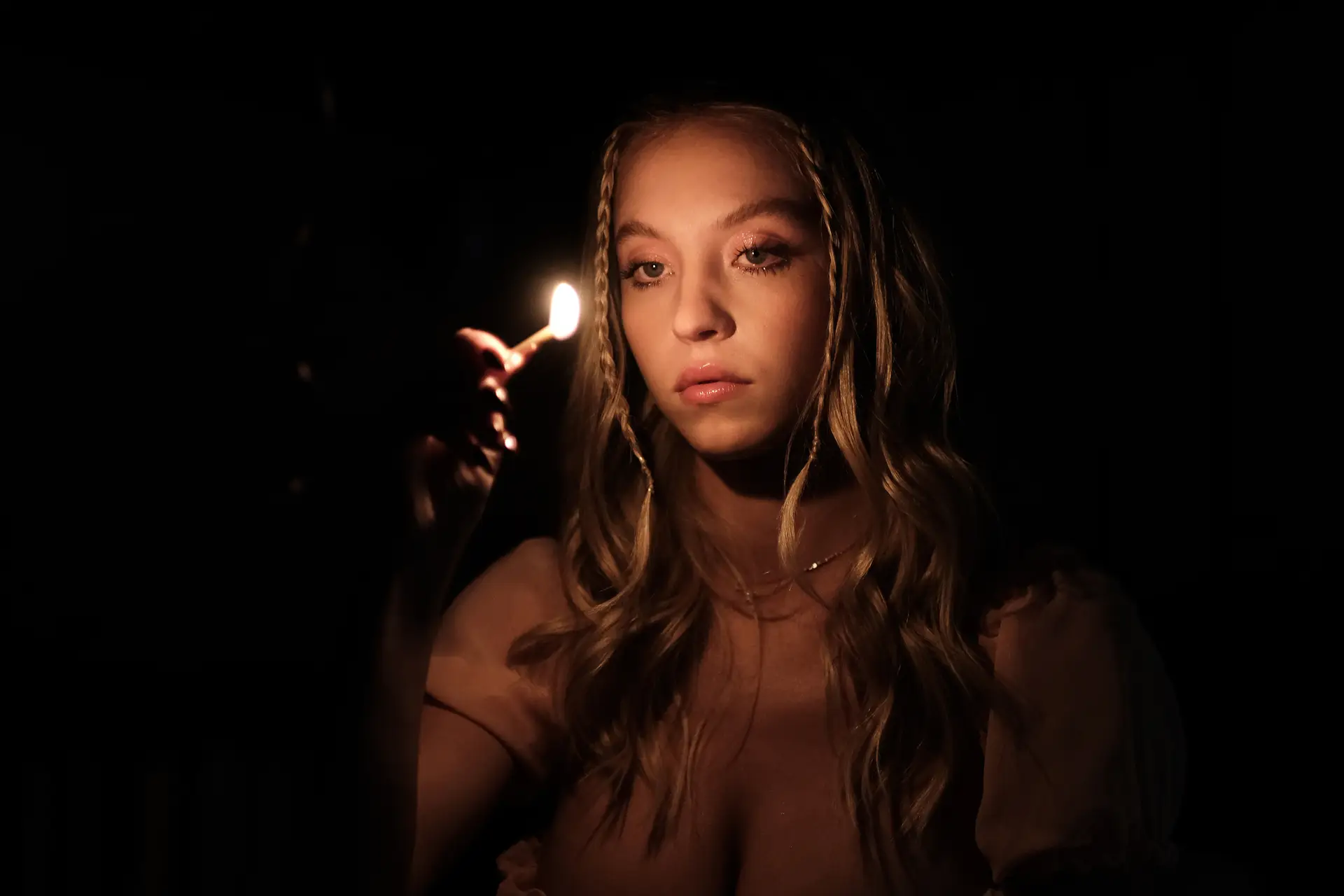 Sydney Sweeney holding a lit match as Cassie on season two, episode five of 