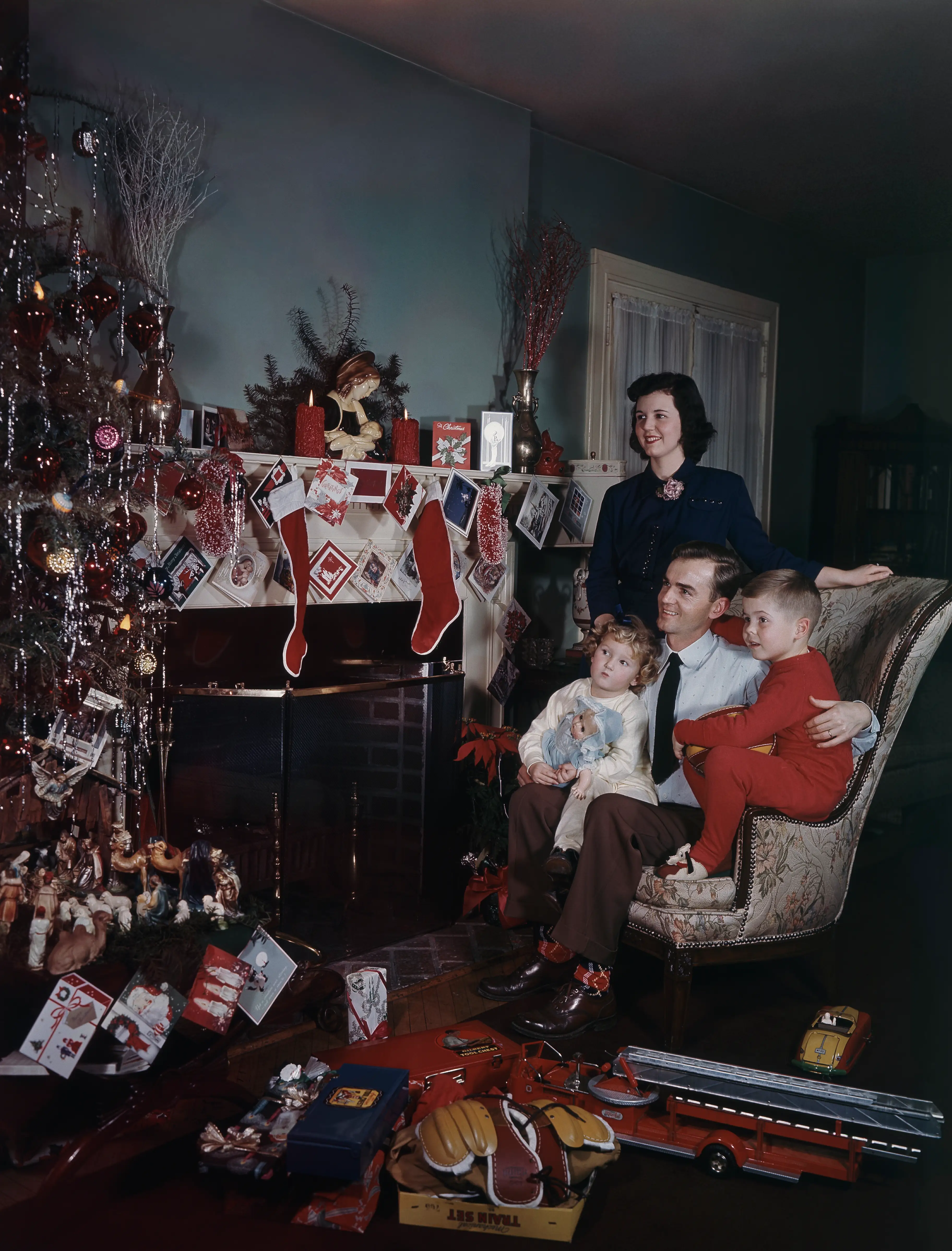 A family looking at a Christmas tree in 1948