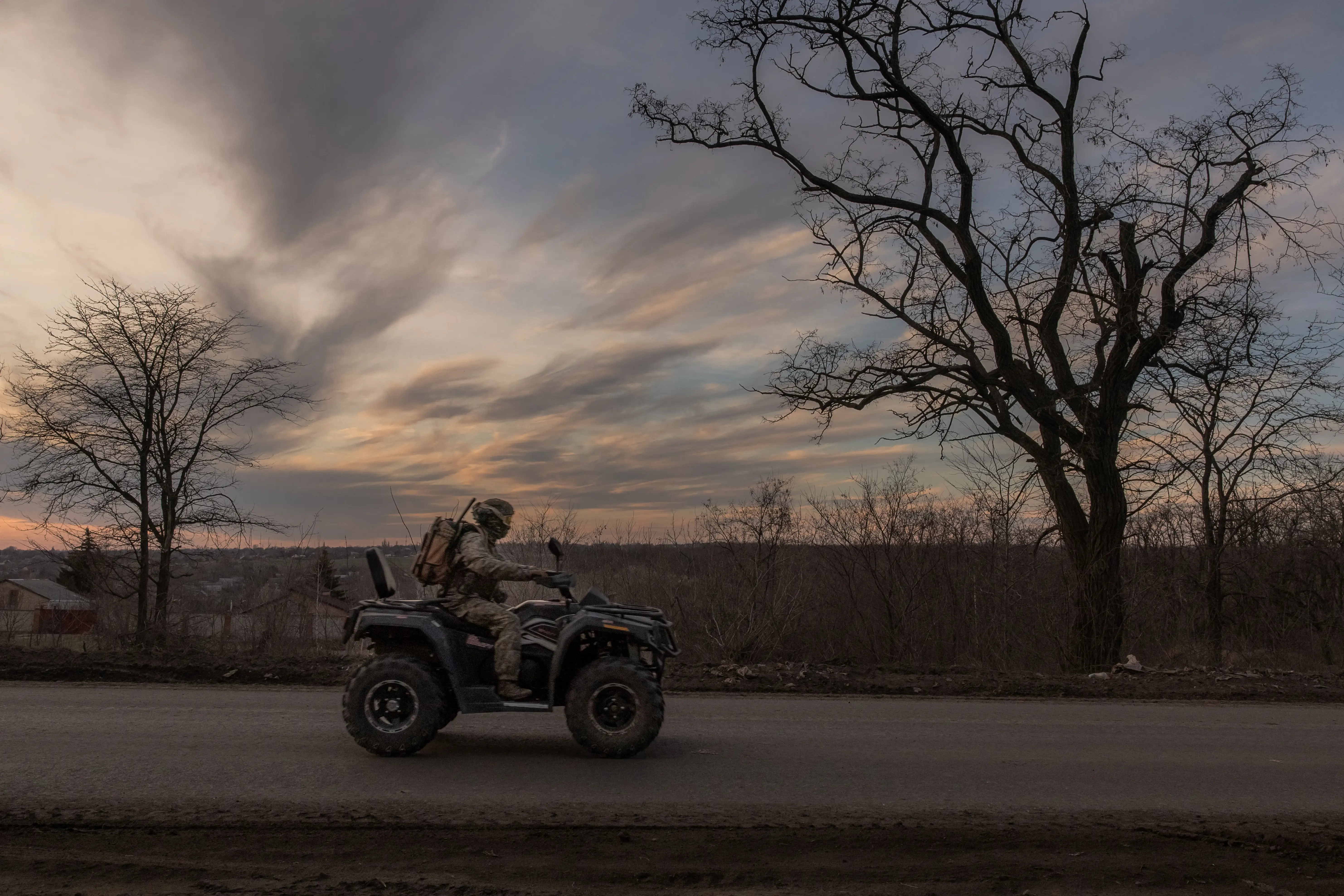 A Ukrainian serviceman drives a quad bike on a road that leads to the town of Chasiv Yar, in the Donetsk region, on March 30, 2024.
