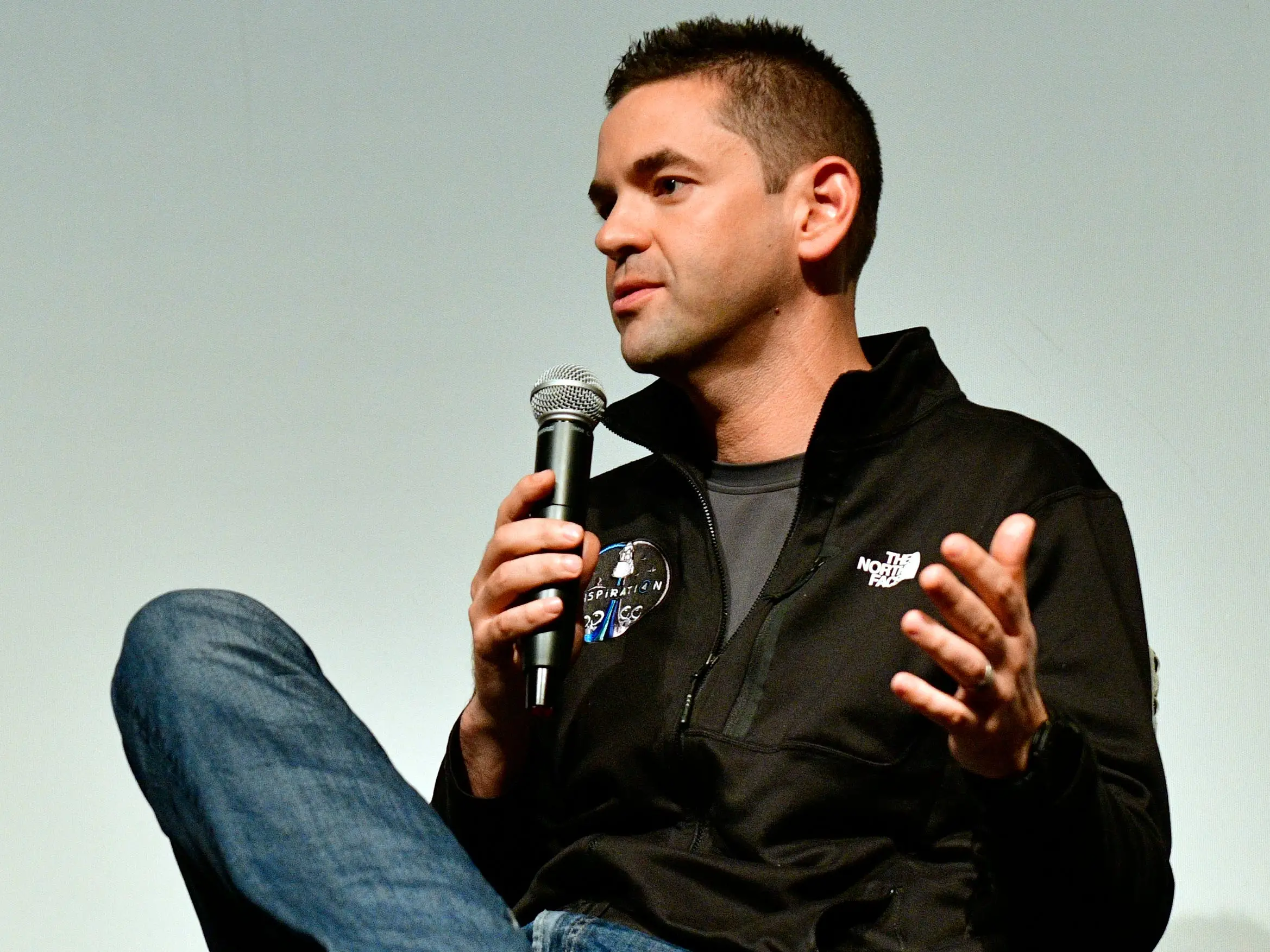 Jared Isaacman holding a mic