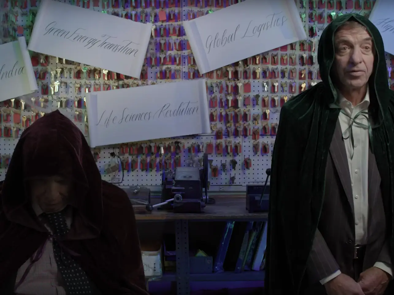 Blackstone executives in robes stand in front of scrolls with things like