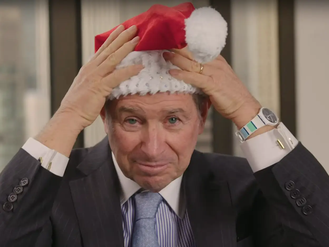 Steve Schwarzman plays with a bedazzled Santa Claus hat.
