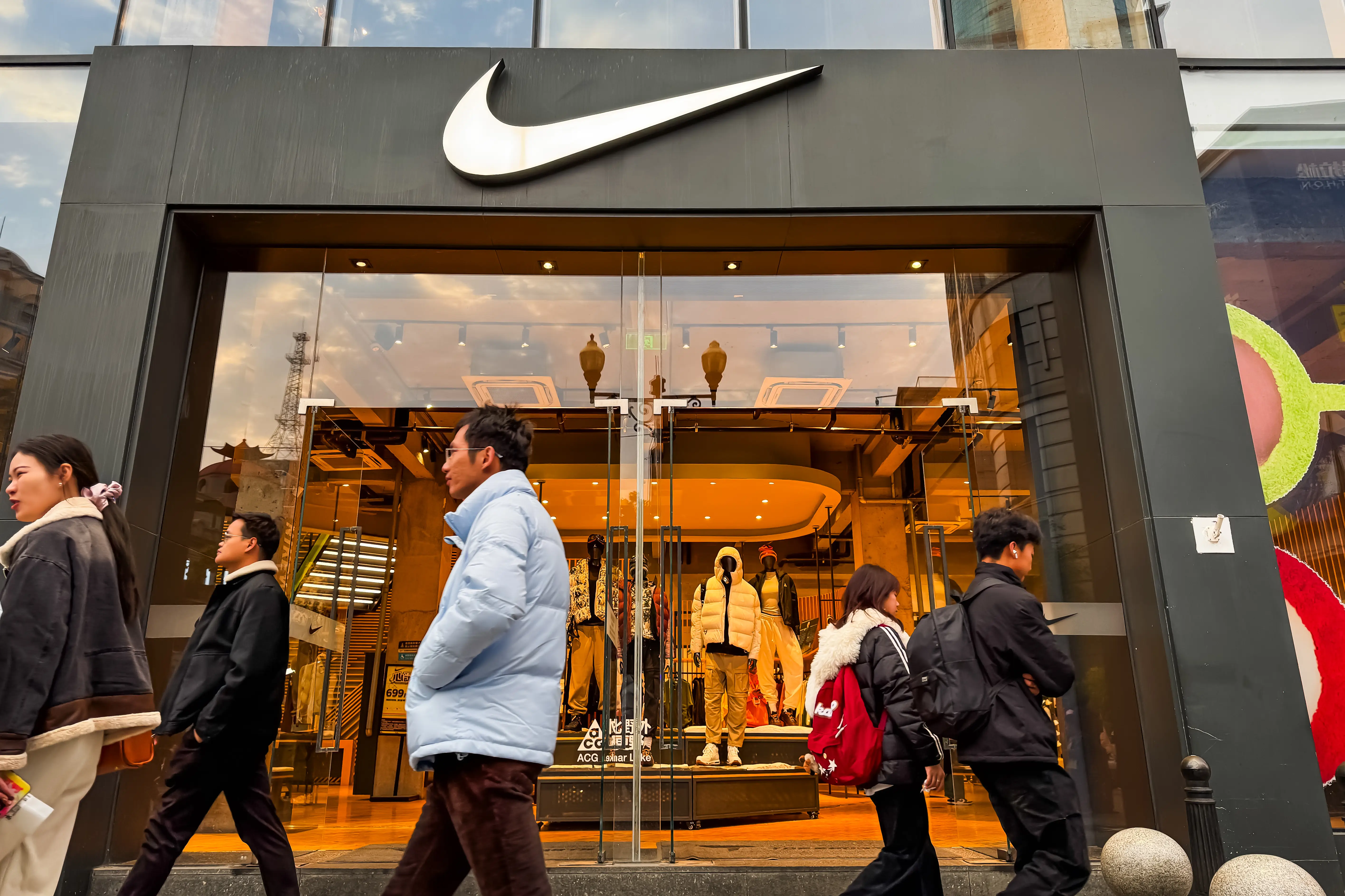 Pedestrians walk past a Nike store in China.