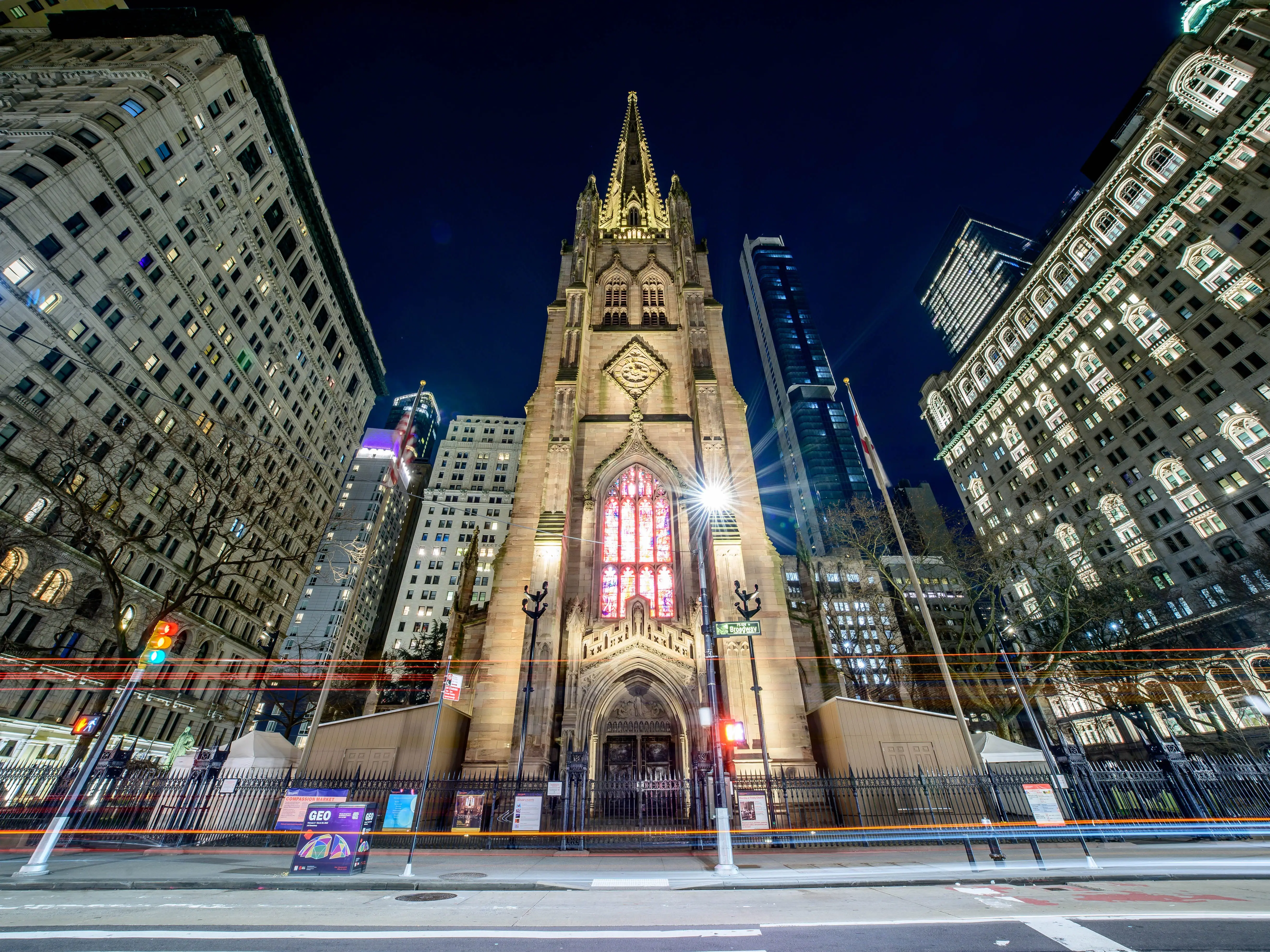 A street view of Trinity Church in lower Manhattan at night.