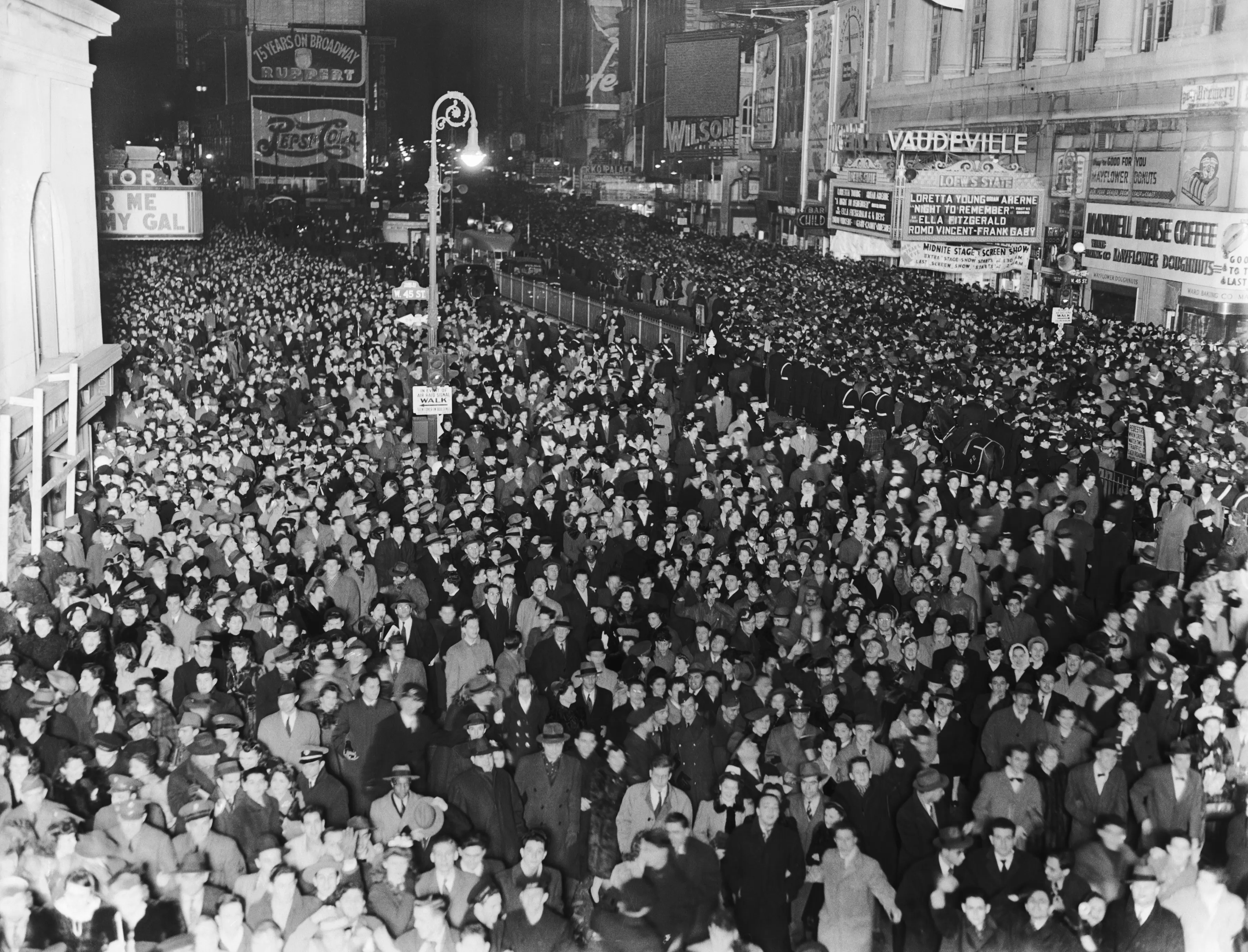 A large crowd of people gathered in Times Square to welcome the year 1943 despite the dim-out.