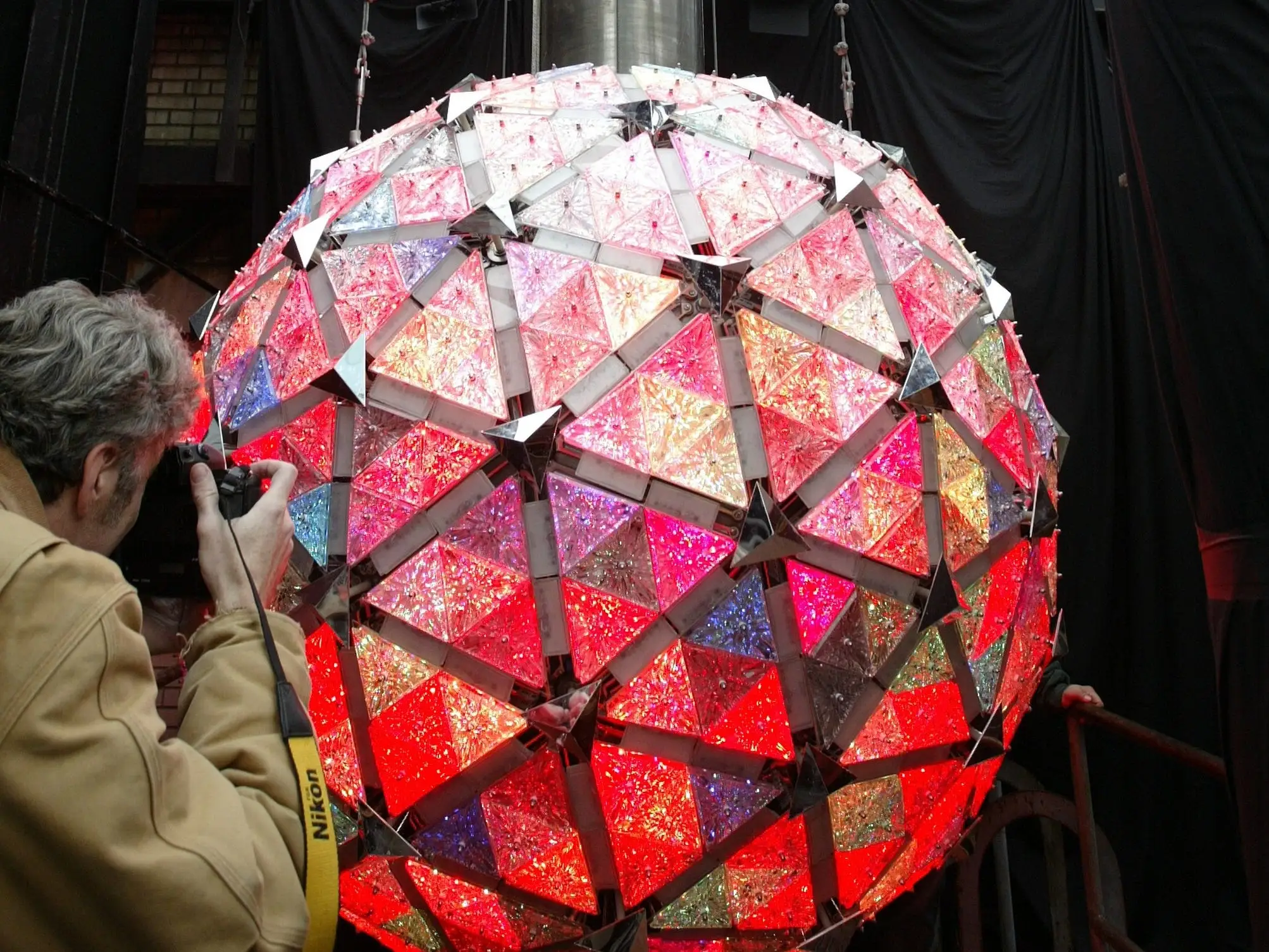 The Times Square ball lit in a rainbow of colors as someone takes a picture in December 2007.