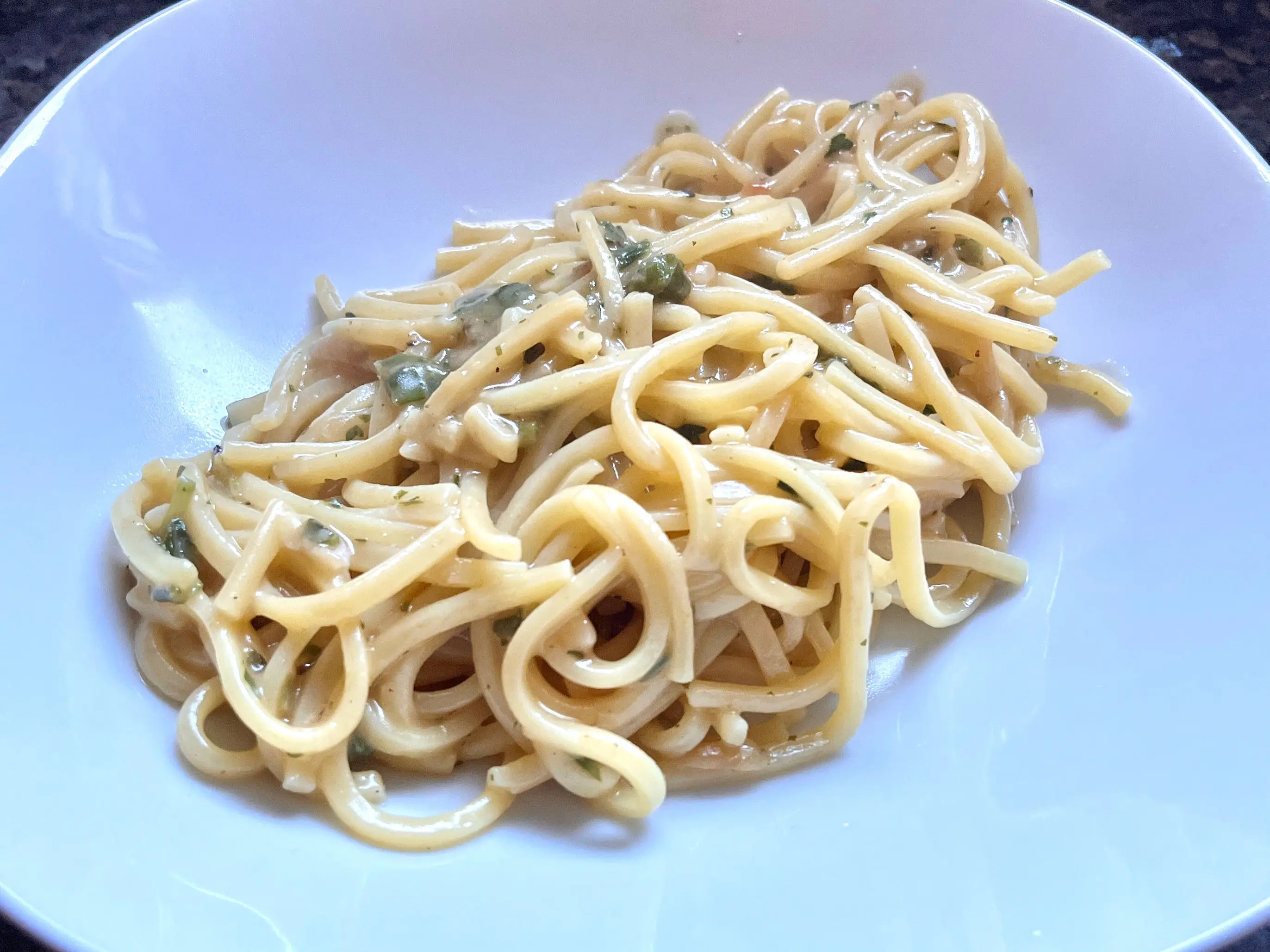 A plate of spaghetti with garlic sauce.