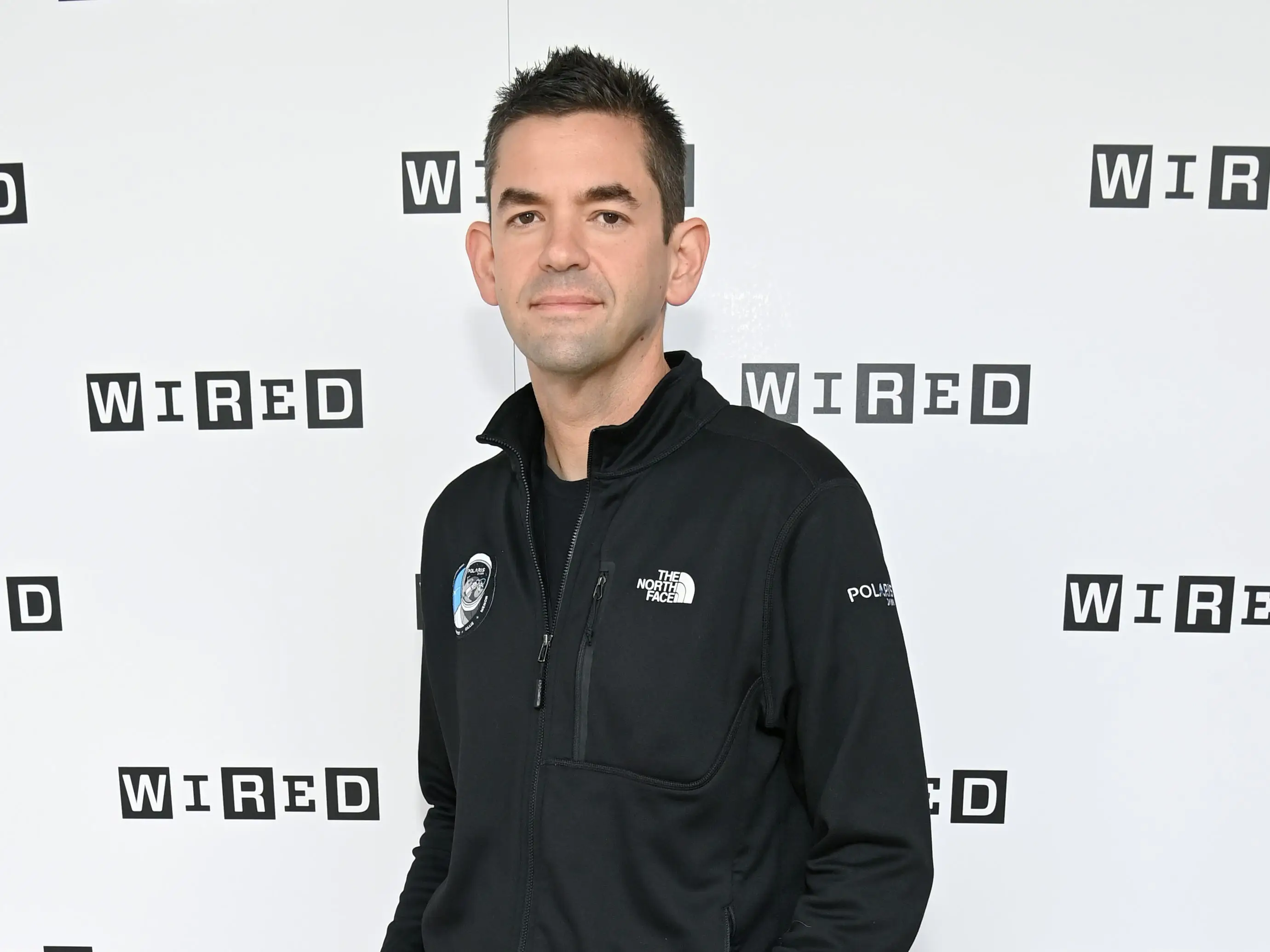 Jared Isaacman standing in front of Wired background