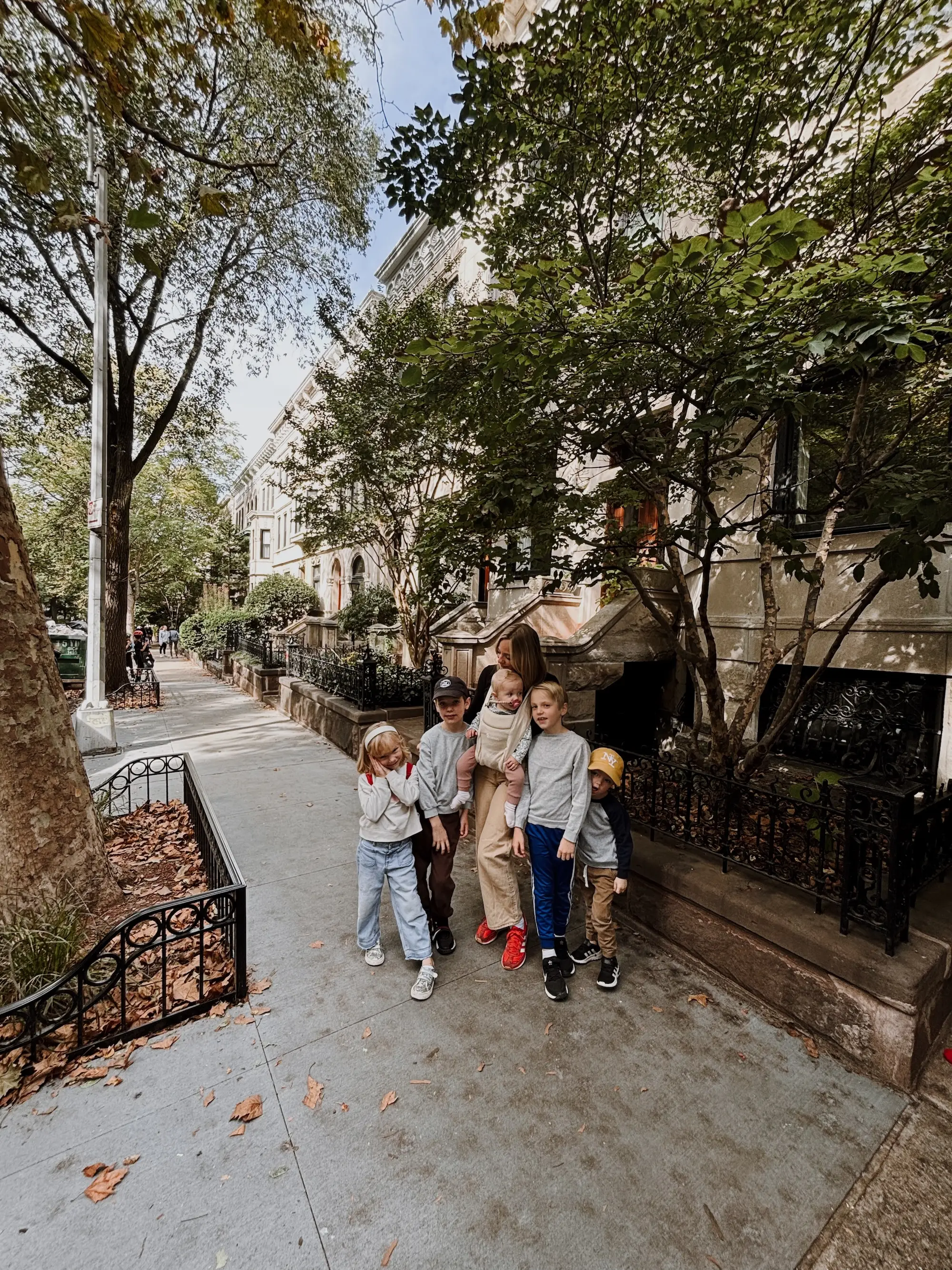 A mother stands with her five children on a street in New York City.