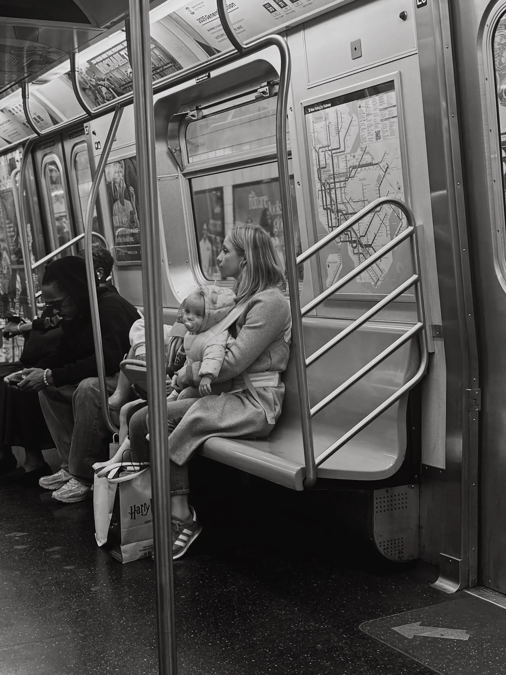 A woman sits on a subway bench with her baby.