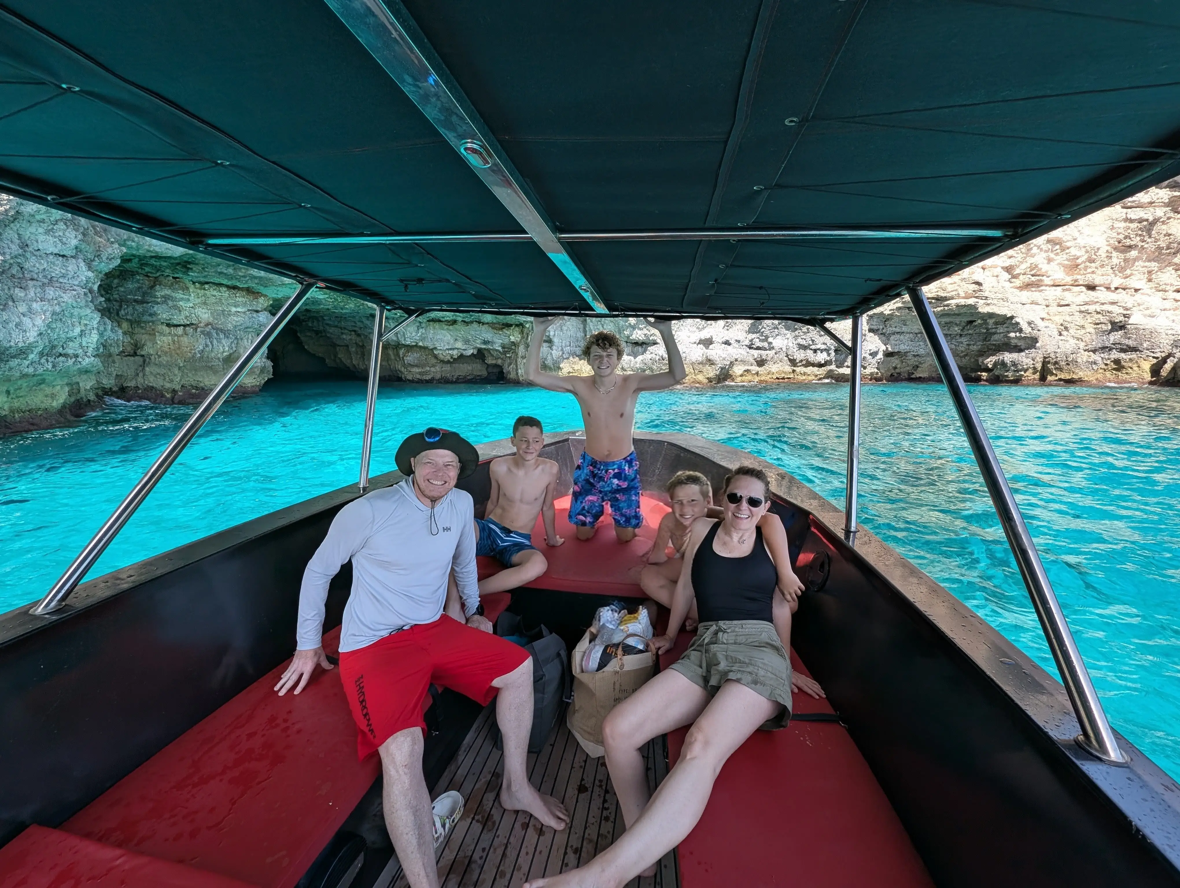 A photo of a man, a woman, and their three sons on a boat in Malta.