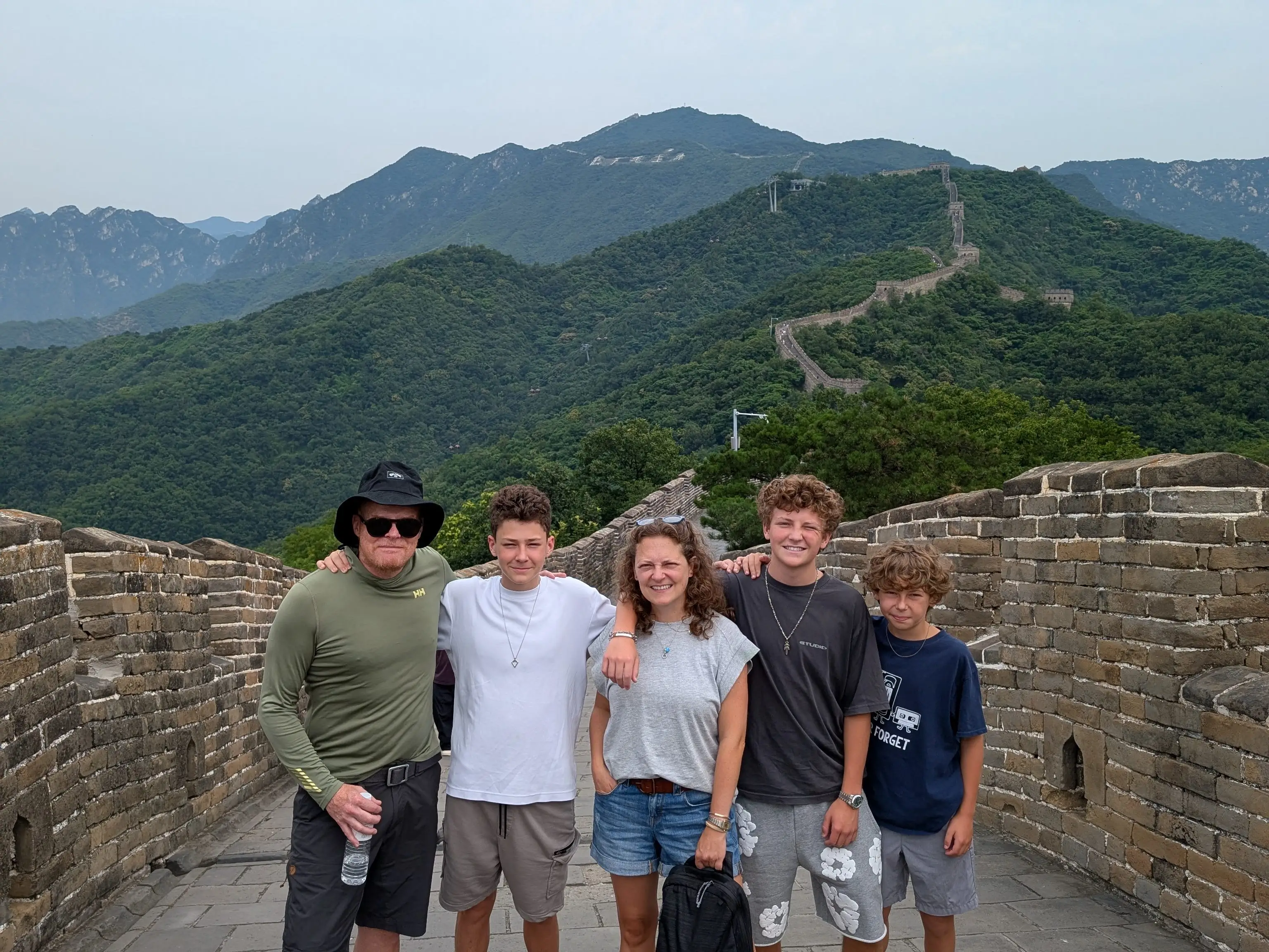 A photo of a man, a woman, and their three sons on the Great Wall of China.